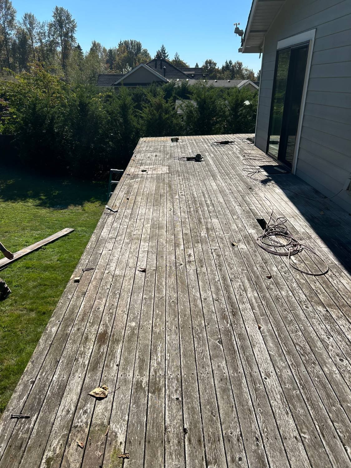 Before: weathered grey wood deck boards