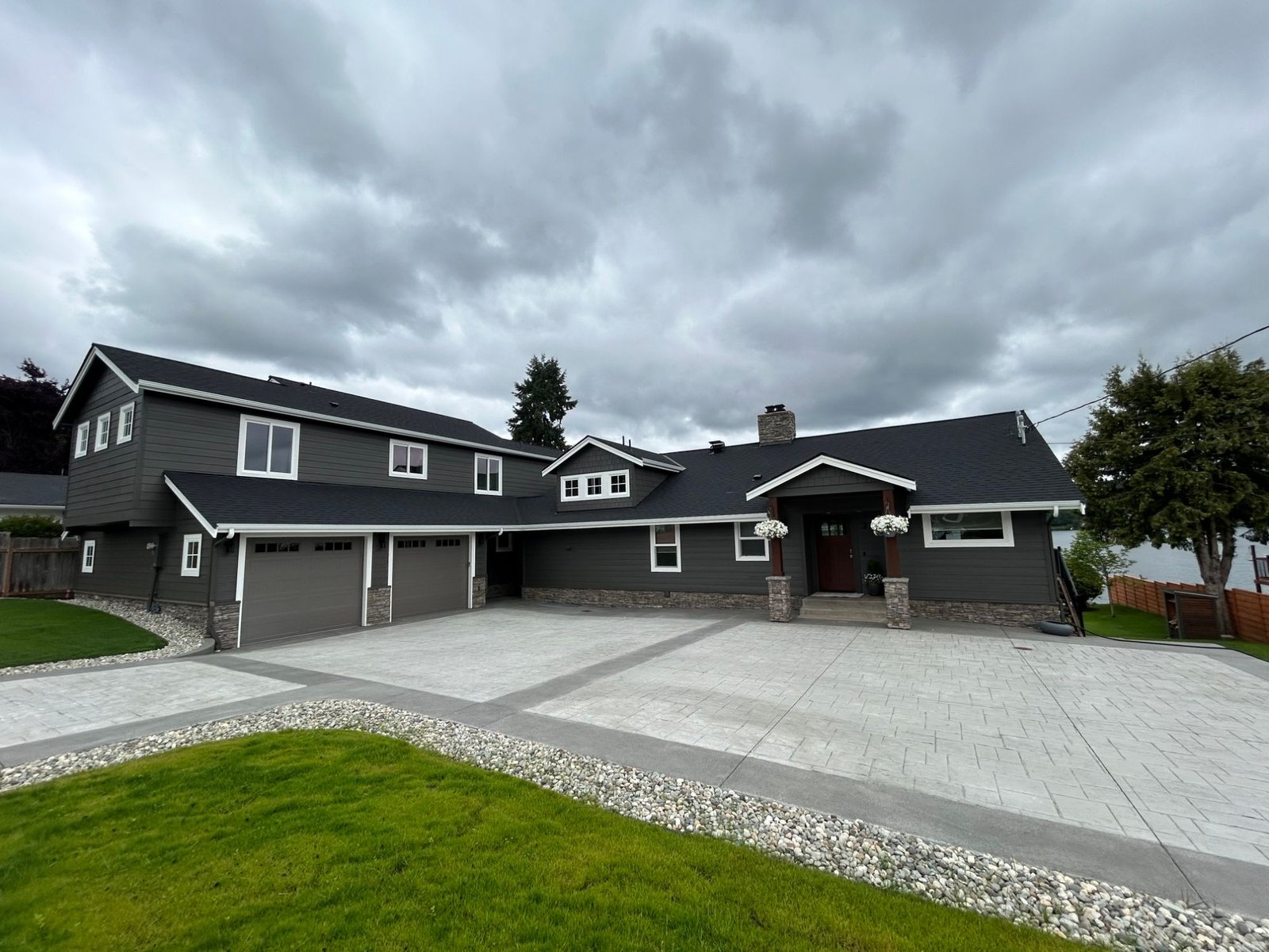After: street side of the property with two garage doors, a covered entry and a stamped concrete driveway