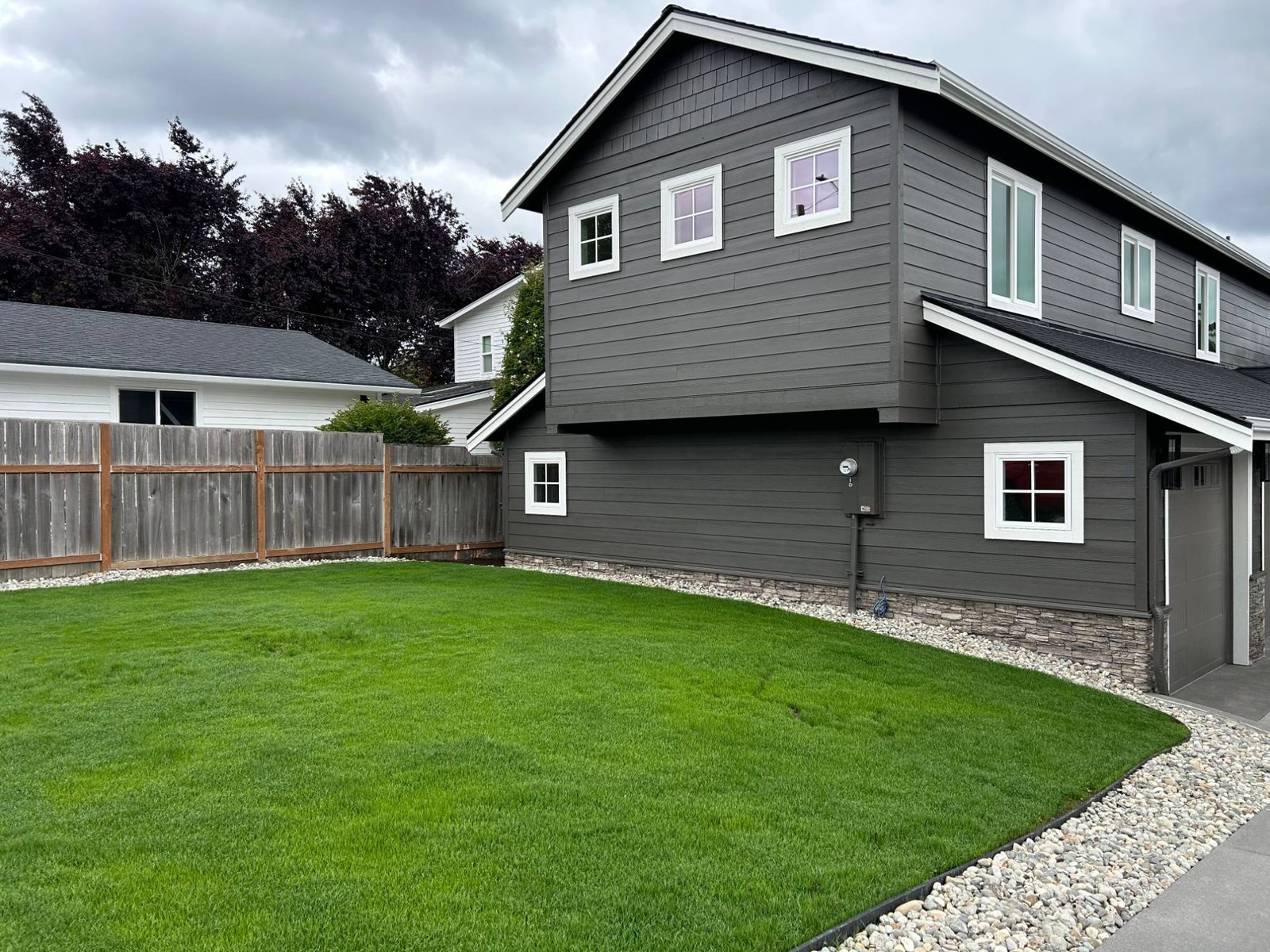 After: side of the two-story wing with a new lawn and river rock border