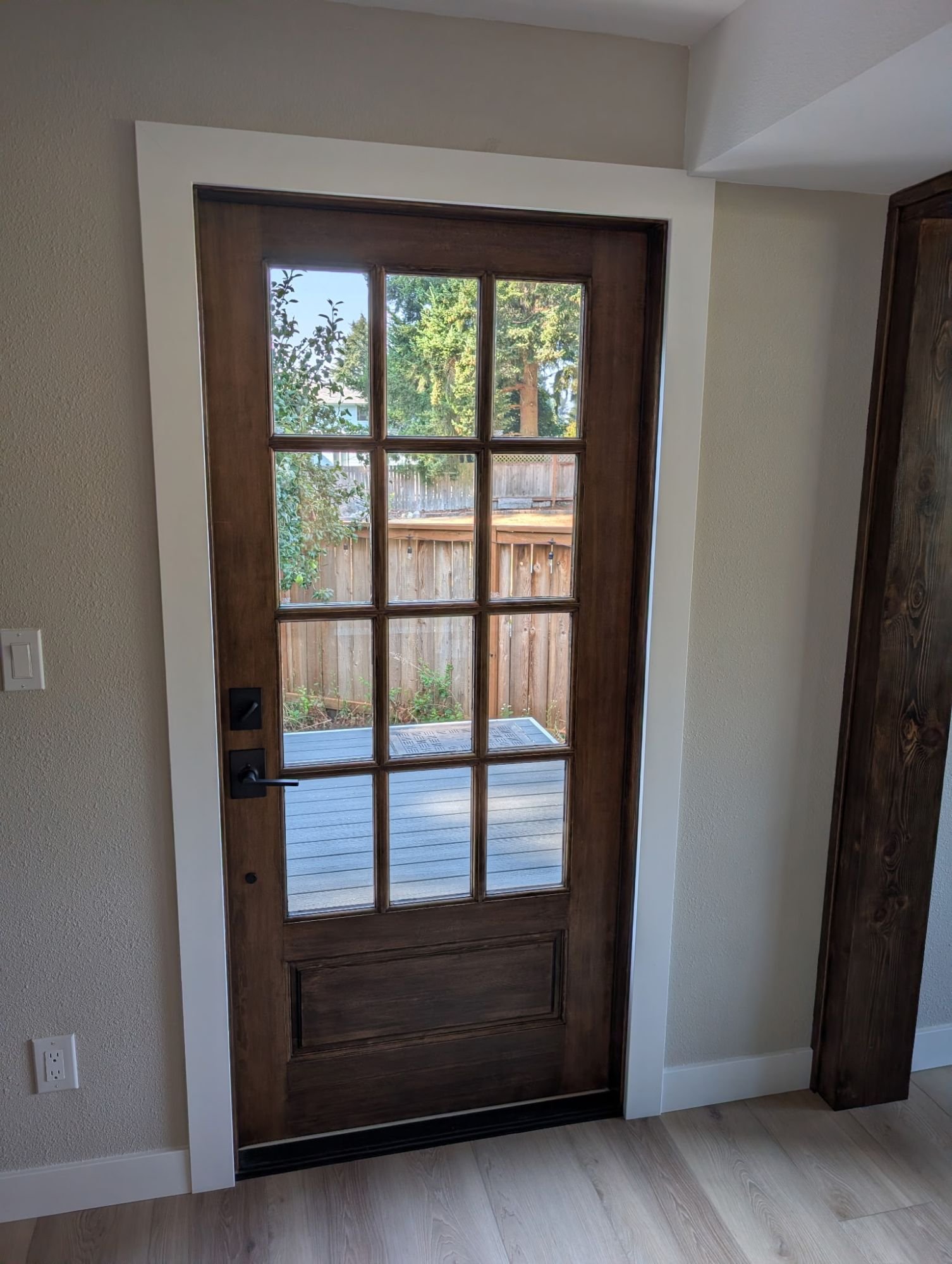 Stained wood divided-light door opening onto a new deck