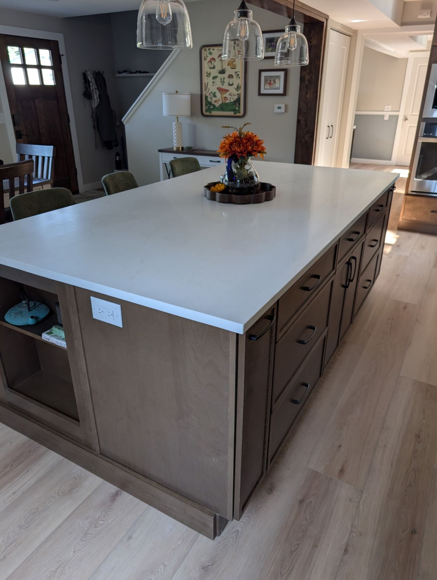 Island detail with drawers, black pulls and an outlet