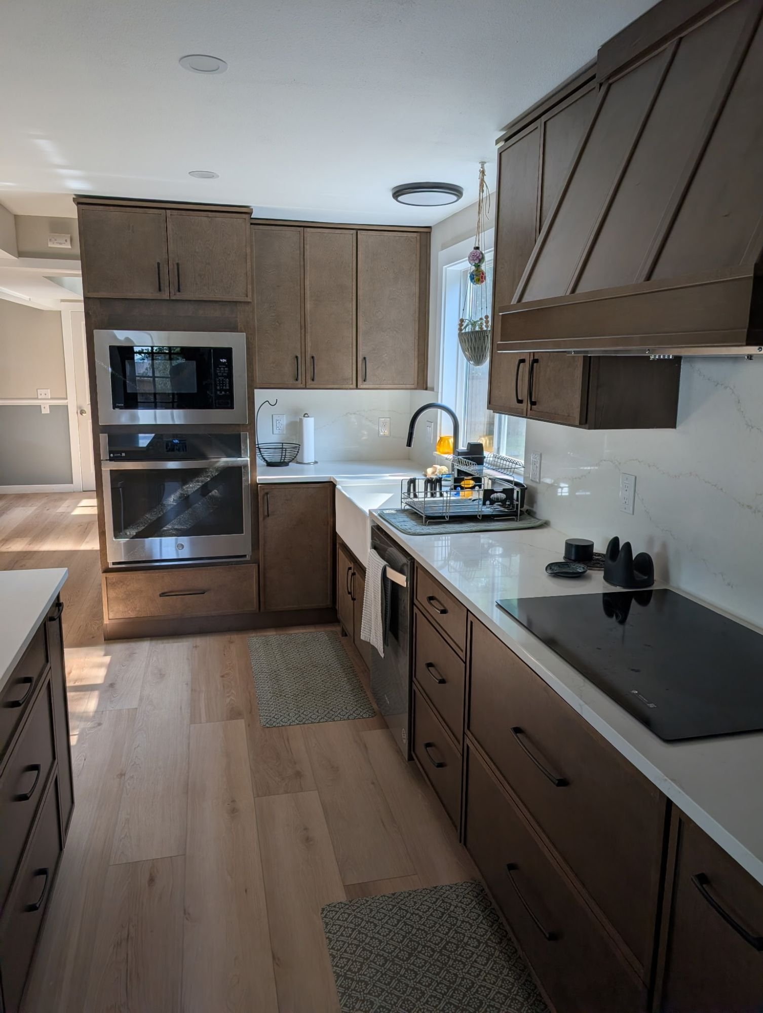 Built-in wall oven and microwave tower beside the farmhouse sink