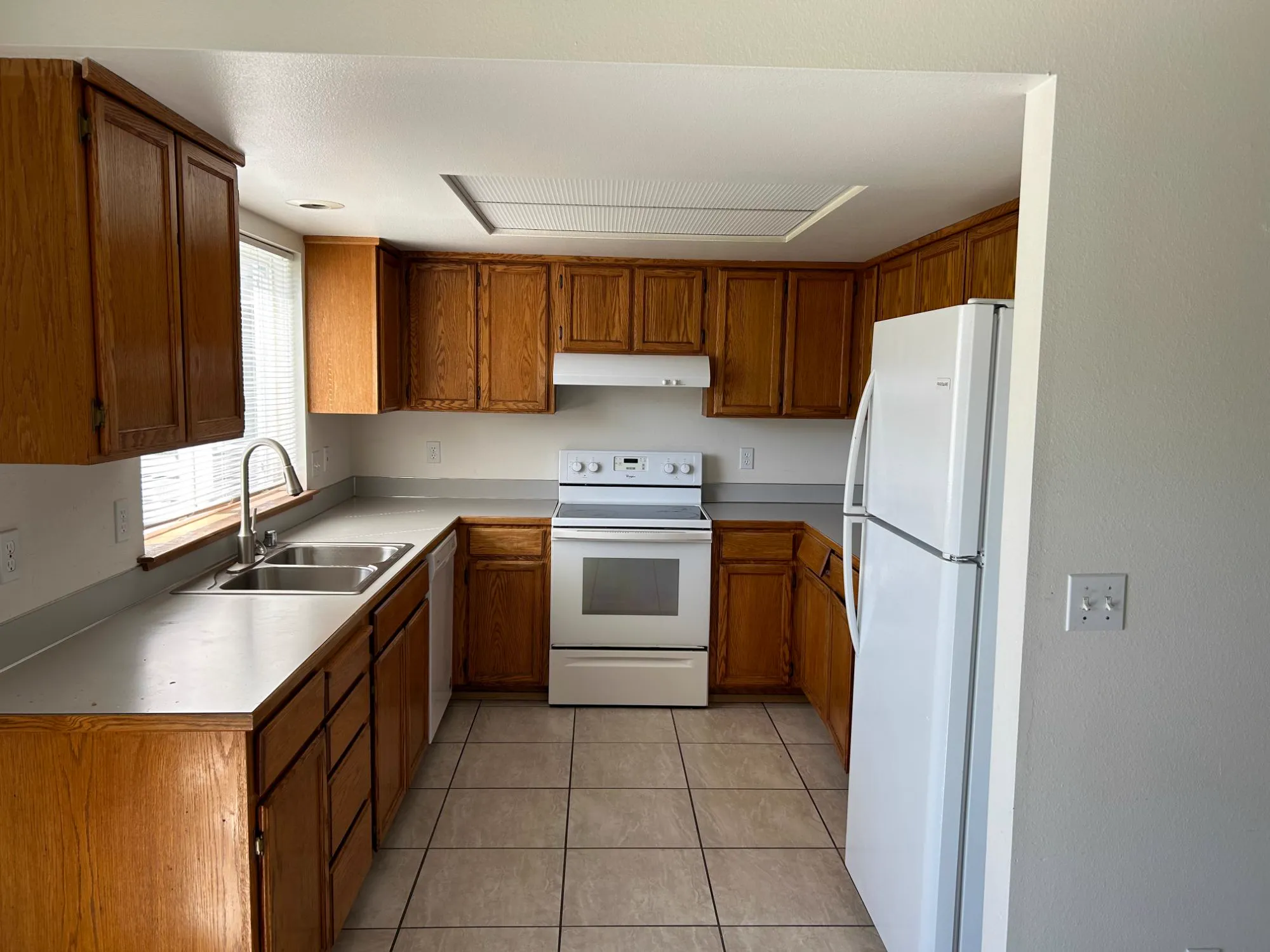 Before: oak cabinet kitchen with laminate counters and white appliances